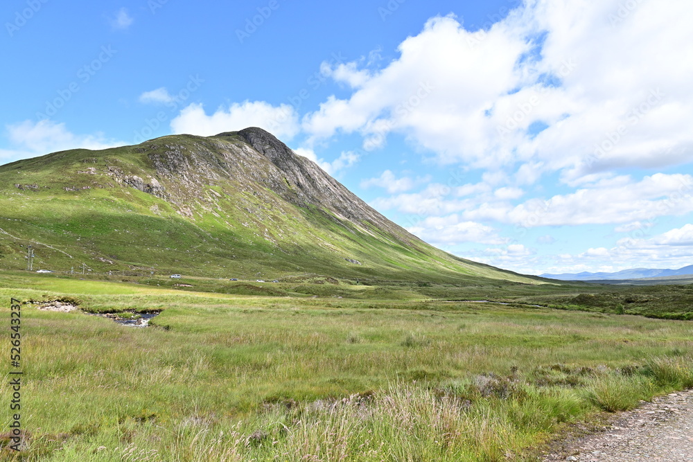 Ausblick auf einem Berg im Tal Glen Coe in den Schottischen Highlands, Glencoe, Argyll, Schottland bei blauem Himmel Ausblick auf einem Berg im Tal Glen Coe in den Schottischen Highlands, Glencoe, Argyll, Schottland bei blauem Himmel