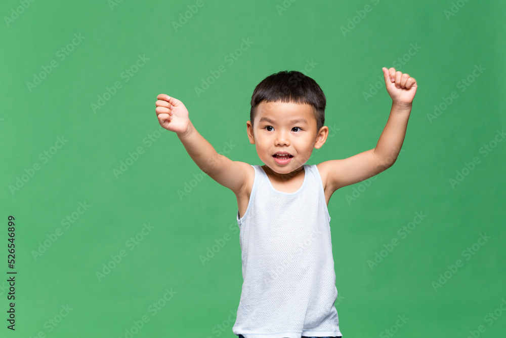 Excited little boy over green background