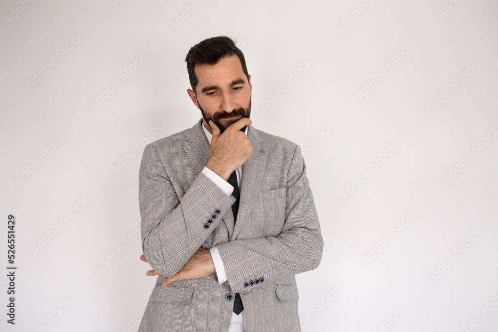 Portrait of serious bearded man. Male model in suit against white background, thinking. Portrait, studio shot, decision concept Portrait of serious bearded man. Male model in suit against white background, thinking. Portrait, studio shot, decision concept