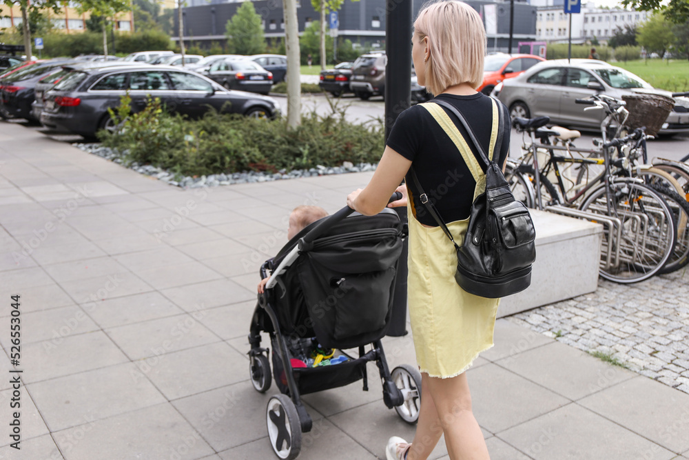 young mother walking with a stroller on the street