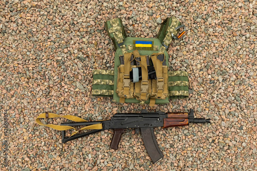 Military body armor and a Kalashnikov assault rifle. Body armor with