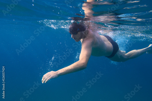 Sporty man swims fast in the sea