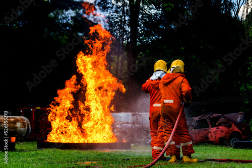 Firefighter Concept. Fireman using water and extinguisher to fighting with fire flame. firefighters fighting a fire with a hose and water during a firefighting training exercise 