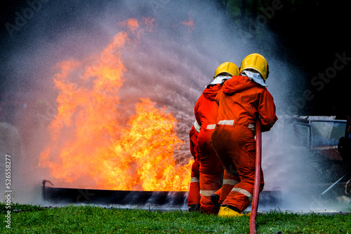 Firefighter Concept. Fireman using water and extinguisher to fighting with fire flame. firefighters fighting a fire with a hose and water during a firefighting training exercise 