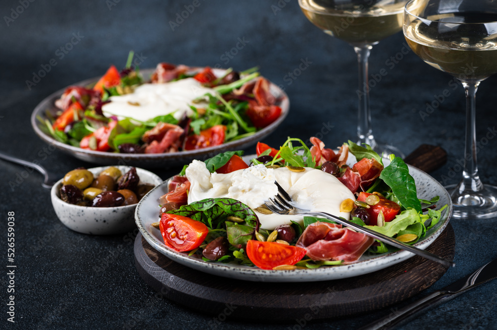 Burrata, Italian fresh cheese made from cream and milk of buffalo or cow. Burrata salad with tomatoes and salad mix. Healthy eating concept. Keto diet salad. Burrata, Italian fresh cheese made from cream and milk of buffalo or cow. Burrata salad with tomatoes and salad mix. Healthy eating concept. Keto diet salad.