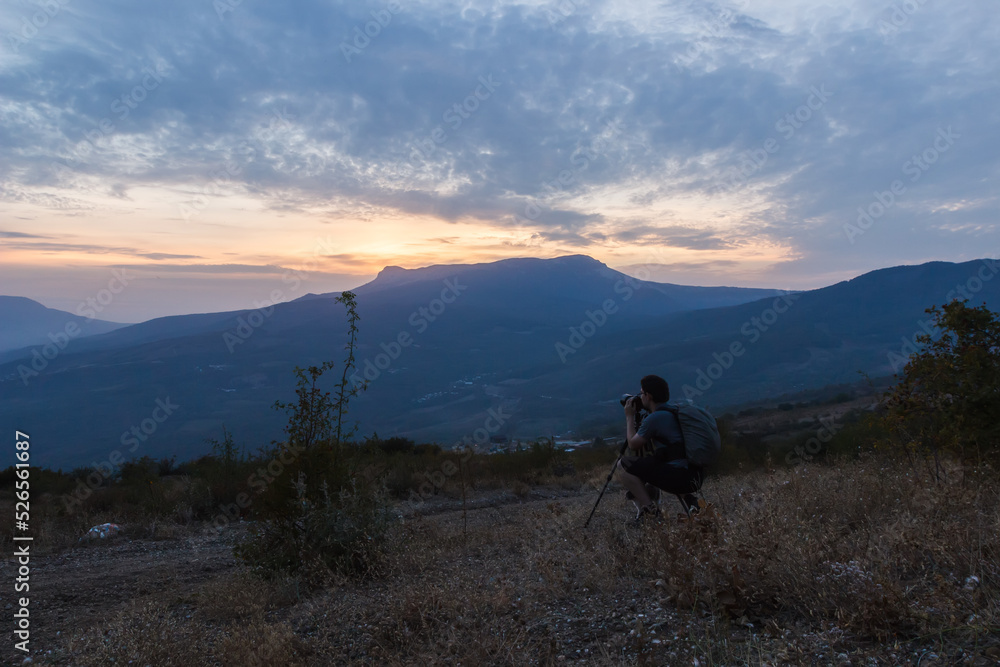 Photographer with a tripod against the background of Demerdzhi rocks