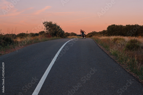 man on surfskate, surfing the  highway, in a small town , nature