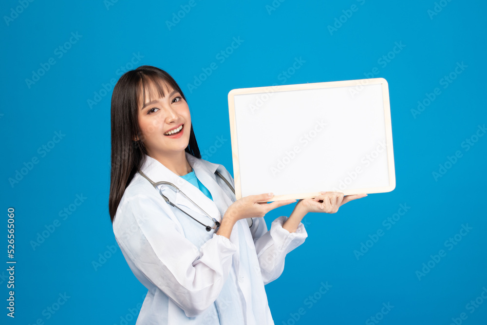 Smiling doctor holding blank banner or card with stethoscope on blue background Smiling doctor holding blank banner or card with stethoscope on blue background