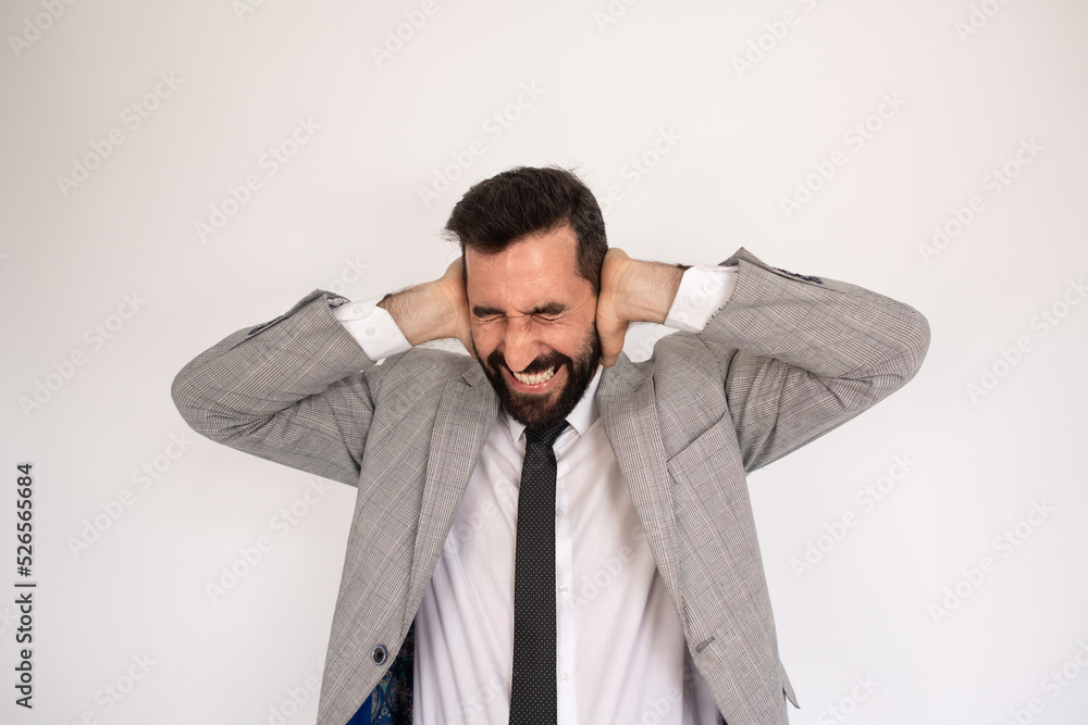 Irritated bearded man closing ears. Portrait of unhappy bearded man with closed eyes. Annoyance concept Irritated bearded man closing ears. Portrait of unhappy bearded man with closed eyes. Annoyance concept