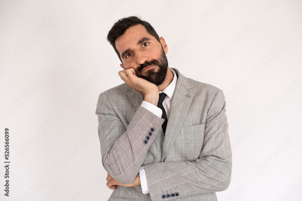 Portrait of unhappy bearded man. Male model in suit against white background, thinking. Portrait, studio shot, decision concept Portrait of unhappy bearded man. Male model in suit against white background, thinking. Portrait, studio shot, decision concept