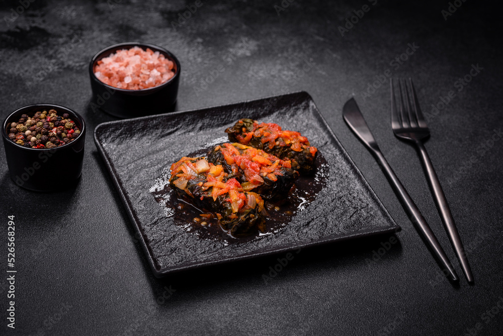Dolma, stuffed grape leaves with rice and meat on a dark background Dolma, stuffed grape leaves with rice and meat on a dark background