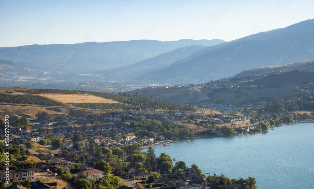 Scenic View of Kalamalka Lake and a small City during sunny summer sunrise. Vernon, British Columbia, Canada.