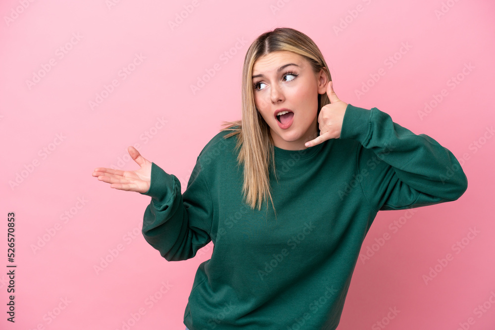 Young caucasian woman isolated on pink background making phone gesture and doubting Young caucasian woman isolated on pink background making phone gesture and doubting