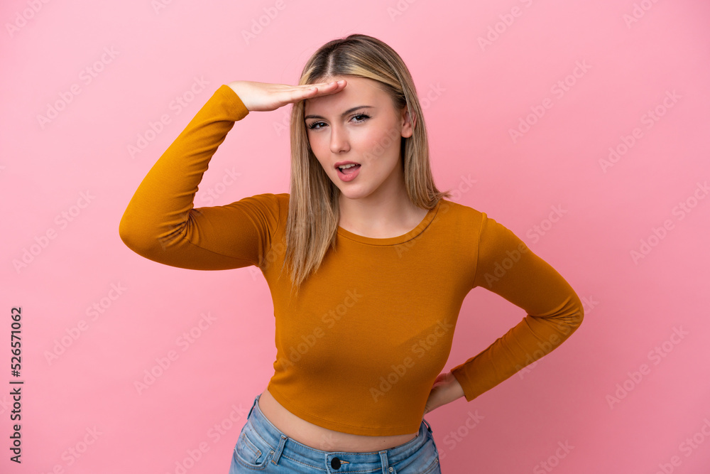 Young caucasian woman isolated on pink background looking far away with hand to look something Young caucasian woman isolated on pink background looking far away with hand to look something