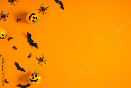 Halloween decorations concept. Halloweenwith big spiders pumpkin and bats on orange background. Flat lay, top view, copy space