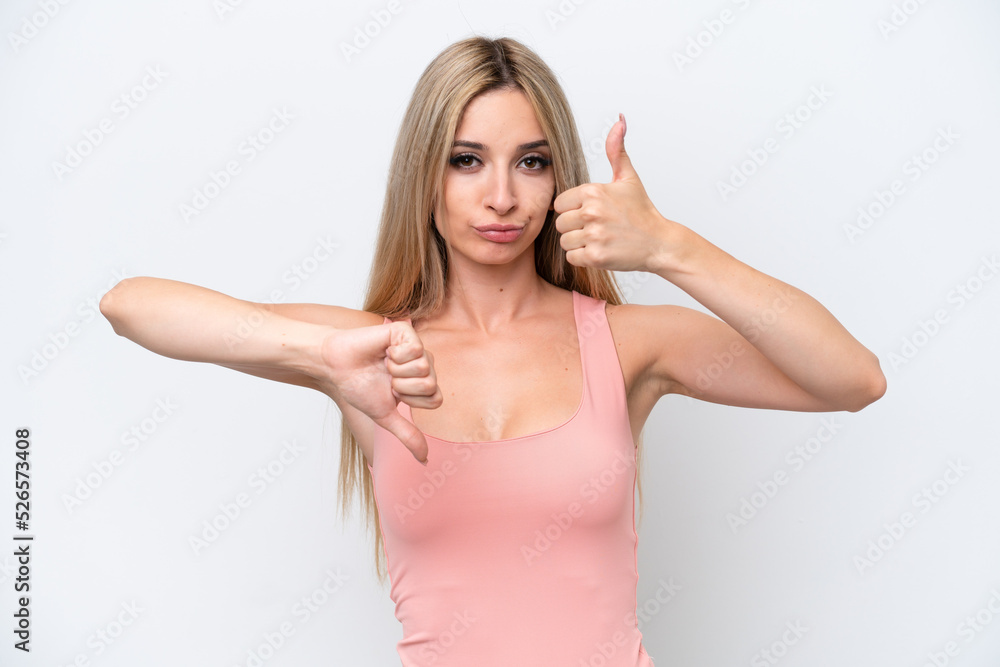 Pretty blonde woman isolated on white background making good-bad sign. Undecided between yes or not Pretty blonde woman isolated on white background making good-bad sign. Undecided between yes or not