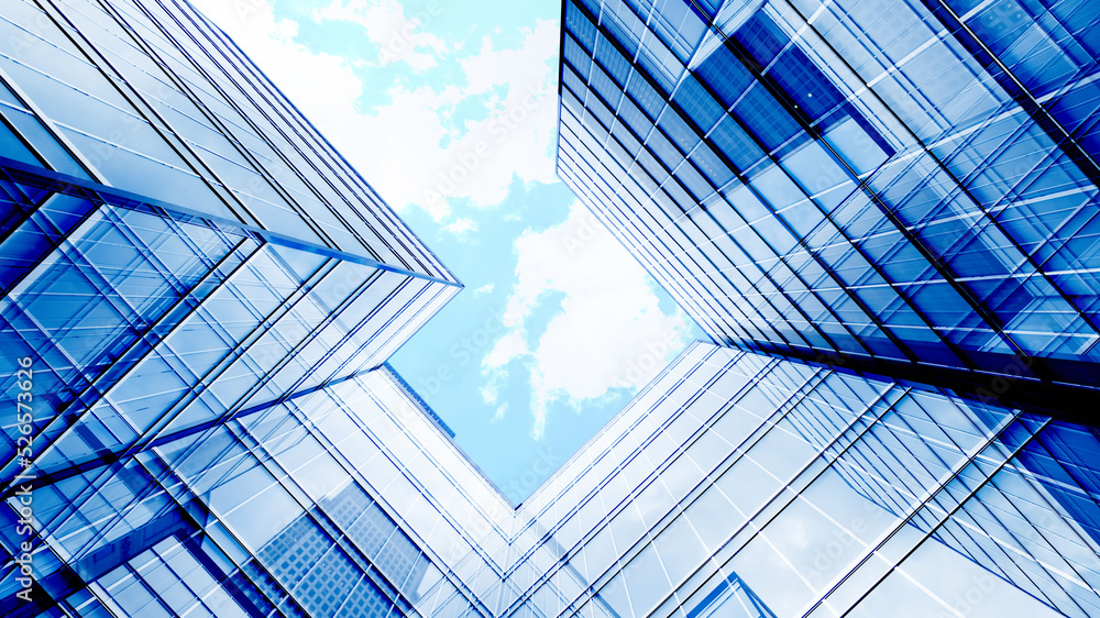 Glass buildings business concept. The glass facade of a skyscraper with a mirror reflection of sky windows. Modern office building with glass facade on a clear sky background. 3D Illustration