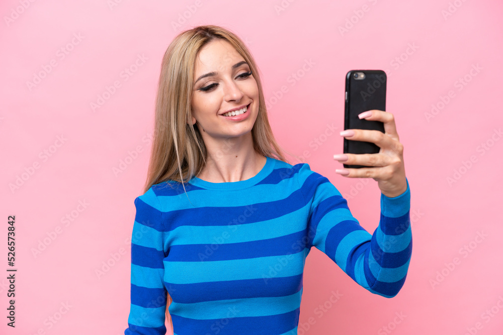 Pretty blonde woman isolated on pink background making a selfie Pretty blonde woman isolated on pink background making a selfie