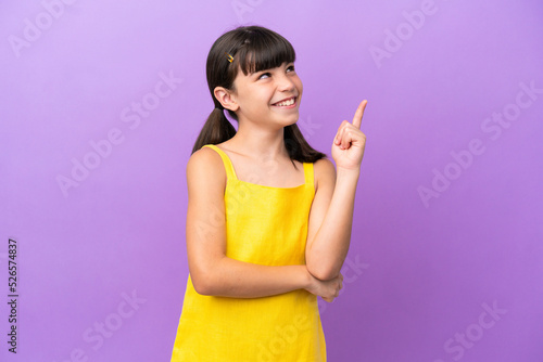 Little caucasian kid isolated on purple background pointing up a great idea