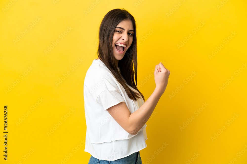 Young caucasian woman isolated on yellow background celebrating a victory Young caucasian woman isolated on yellow background celebrating a victory