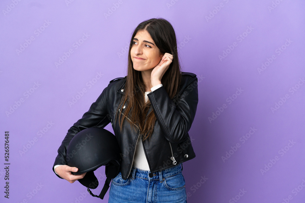 Young caucasian woman with a motorcycle helmet isolated on purple background frustrated and covering ears Young caucasian woman with a motorcycle helmet isolated on purple background frustrated and covering ears