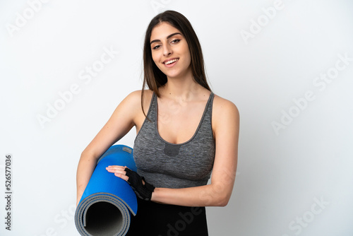 Young caucasian woman isolated on white background with a mat and smiling