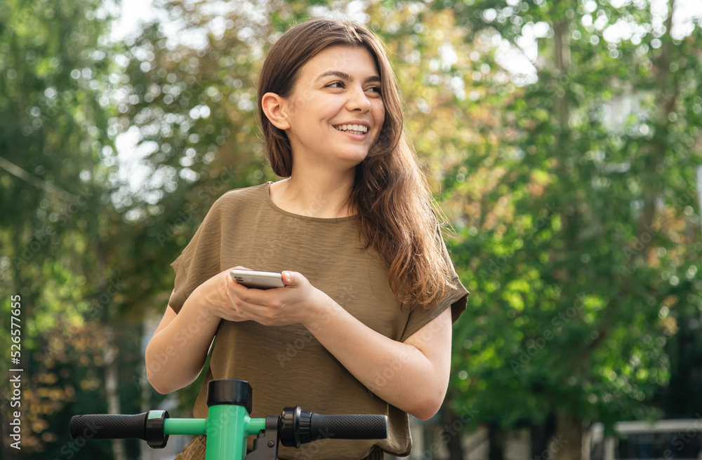 Attractive young woman with a rental electric scooter on a sunny day. Attractive young woman with a rental electric scooter on a sunny day.