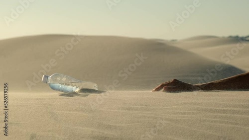 woman feels thirst and drinks water in the desert. a woman's hand lies in the sand and reaches for a bottle of water in the desert of death. female body lies in the desert after dehydration photo