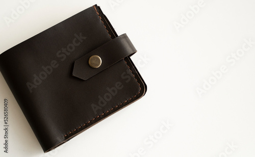 Brown natural genuine leather wallet isolated on white background. Expensive man's purse closeup.