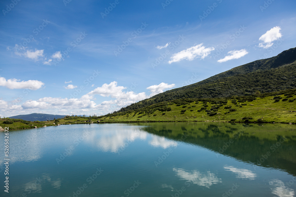 blue sky reflection in the water surface of a mountain lake, Carpathians mountains blue sky reflection in the water surface of a mountain lake, Carpathians mountains