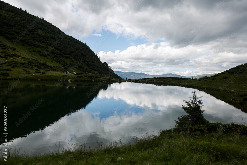 Reflection of the stormy sky in the water surface of a mountain lake, Carpathians