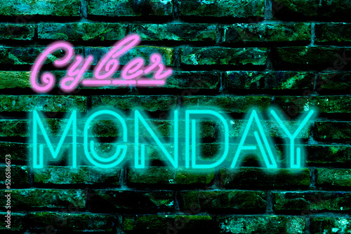 Neon light sign with the text Cyber Monday on a dark brick wall.