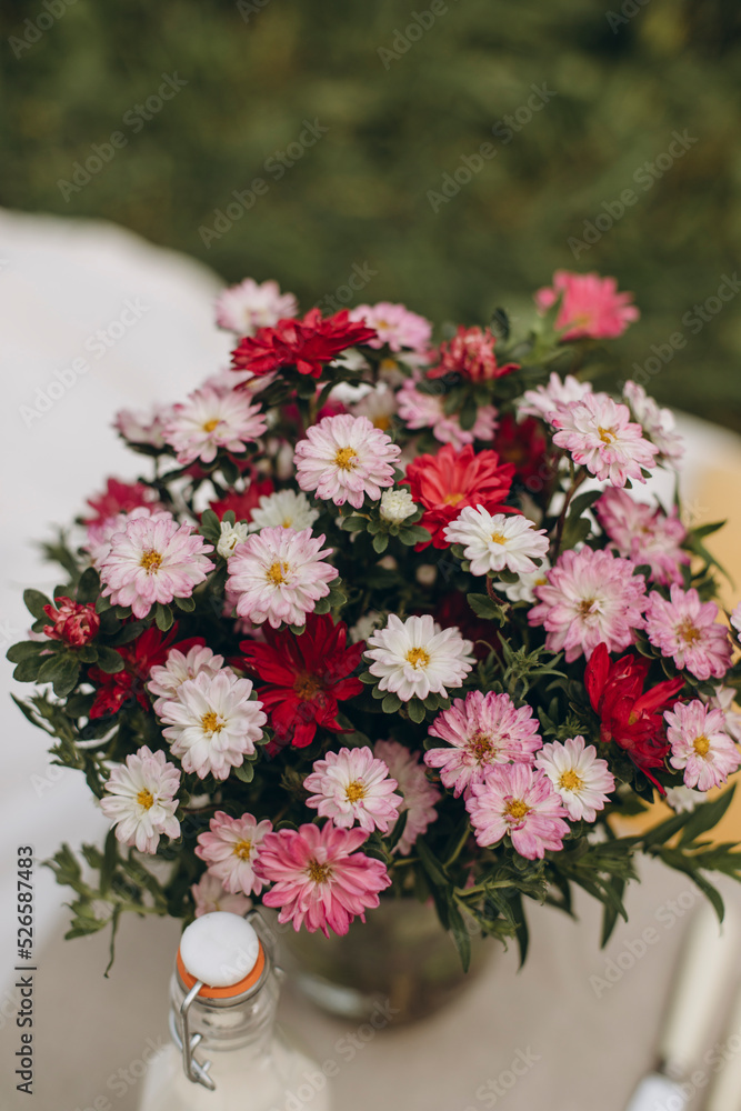 bouquet of colorful asters top view. red, pink and white flowers in a vase outdoors.