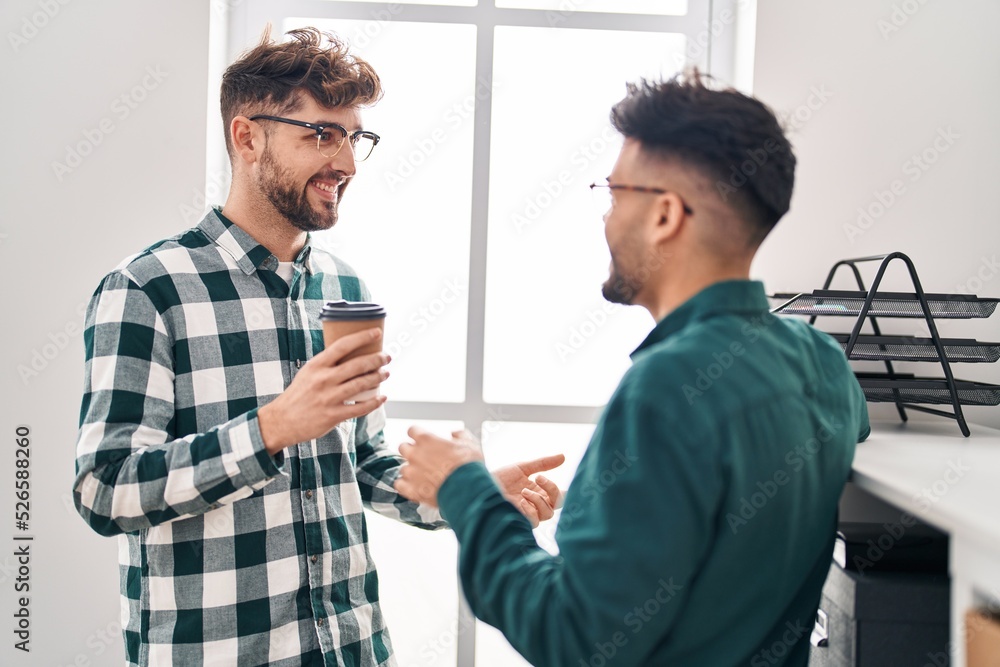 Fototapeta premium Young couple business workers drinking coffee standing at office