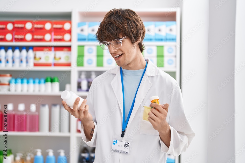 Young blond man pharmacist smiling confident holding pills bottles at pharmacy Young blond man pharmacist smiling confident holding pills bottles at pharmacy