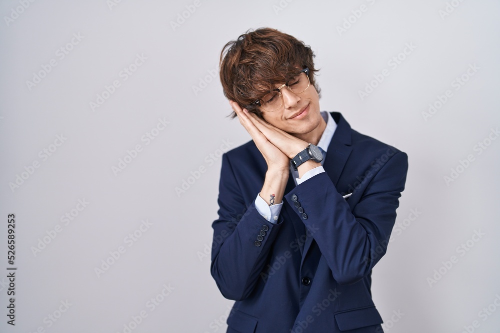 Hispanic business young man wearing glasses sleeping tired dreaming and posing with hands together while smiling with closed eyes. Hispanic business young man wearing glasses sleeping tired dreaming and posing with hands together while smiling with closed eyes.