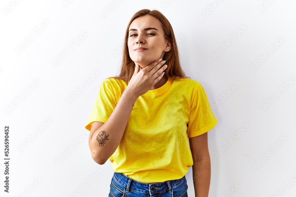 Young brunette woman standing over isolated background touching painful neck, sore throat for flu, clod and infection Young brunette woman standing over isolated background touching painful neck, sore throat for flu, clod and infection