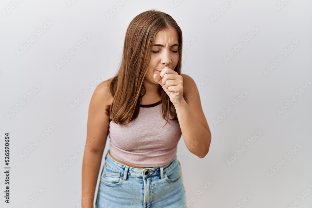 Young brunette woman standing over isolated background feeling unwell and coughing as symptom for cold or bronchitis. health care concept. Young brunette woman standing over isolated background feeling unwell and coughing as symptom for cold or bronchitis. health care concept.