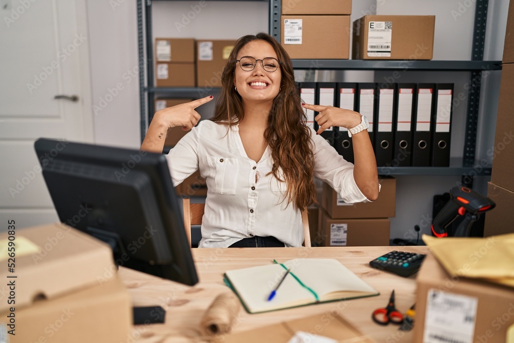 Young hispanic woman working at small business ecommerce smiling with open mouth, fingers pointing and forcing cheerful smile Young hispanic woman working at small business ecommerce smiling with open mouth, fingers pointing and forcing cheerful smile