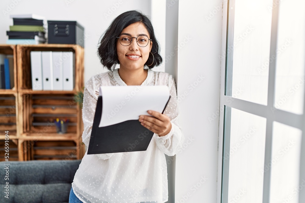 Young latin woman having psychology session writing on clipboard at psychology center Young latin woman having psychology session writing on clipboard at psychology center