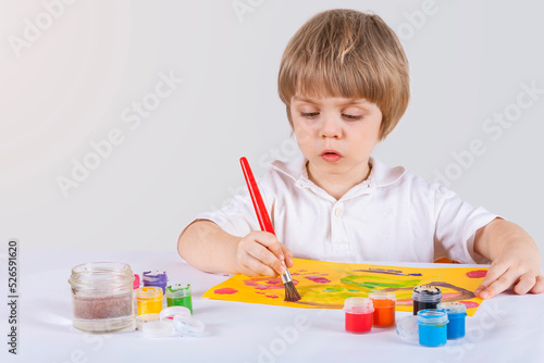 Child draws with paints. Inexplicable strokes of paint on paper