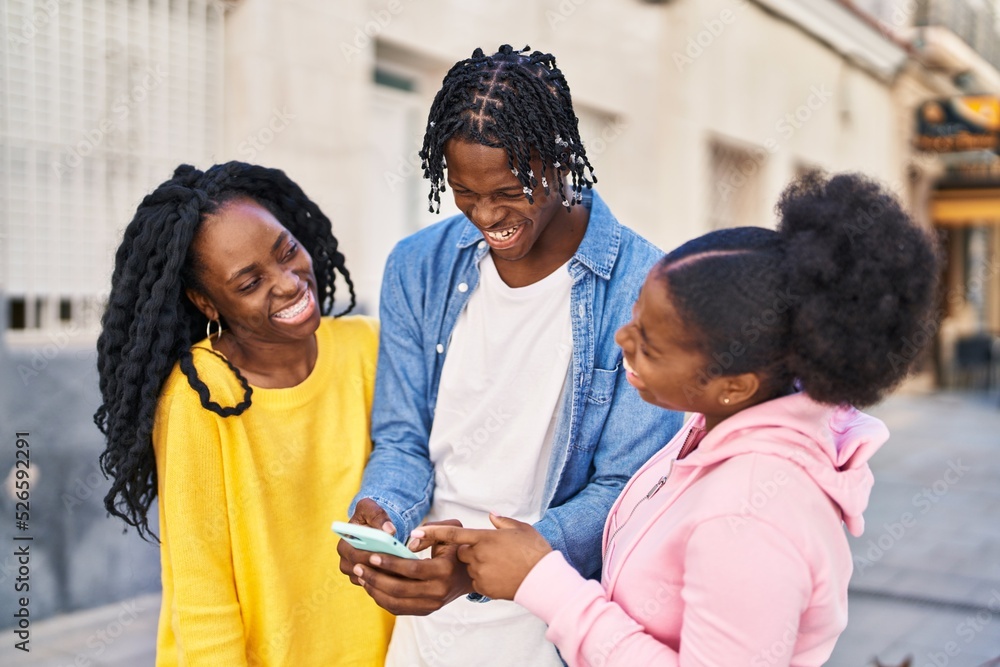 African american friends standing together using smartphone at street African american friends standing together using smartphone at street