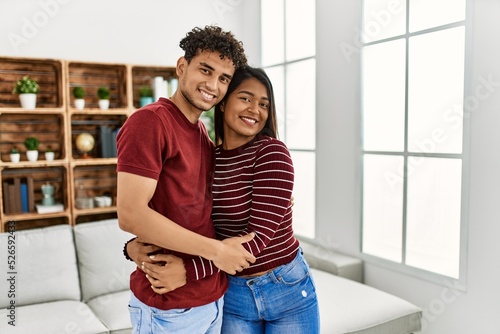 Young latin couple smiling happy and hugging standing at home. © Krakenimages.com