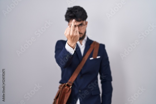 Hispanic man with beard wearing business clothes showing middle finger, impolite and rude fuck off expression