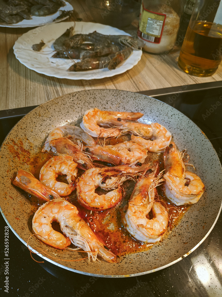 Large shrimps in sauce lie on a dish on the table
