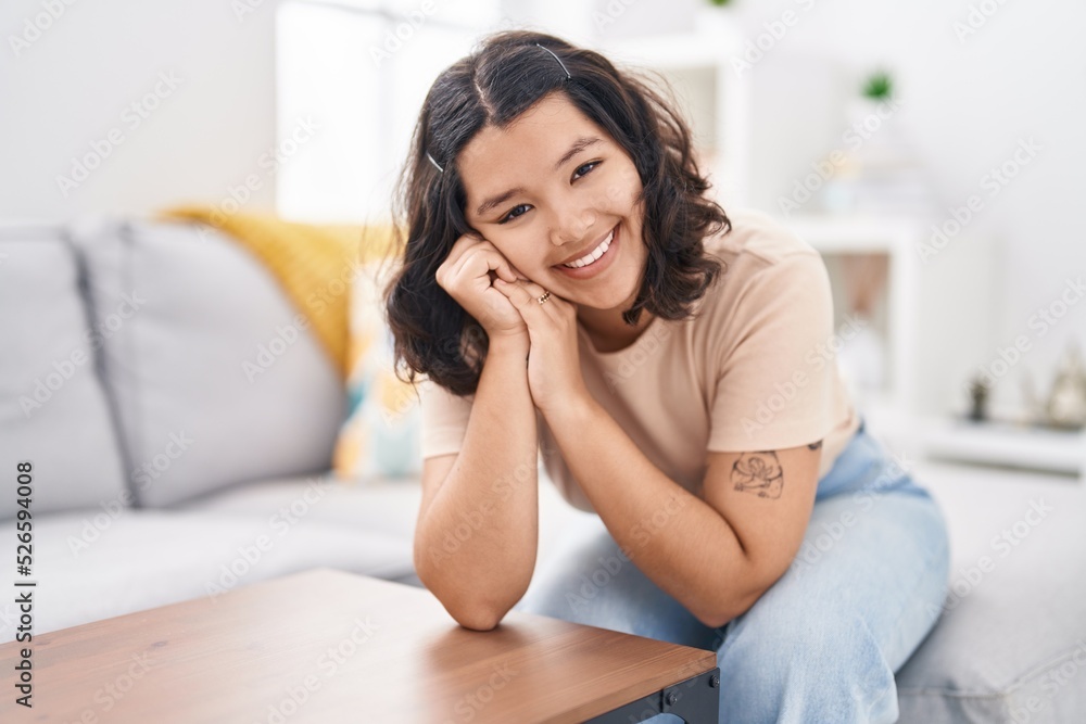 Young woman smiling confident sitting on sofa at home Young woman smiling confident sitting on sofa at home