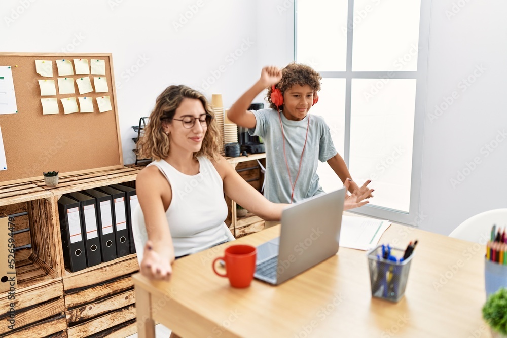 Mother and son doing yoga exercise while child listen music at office Mother and son doing yoga exercise while child listen music at office