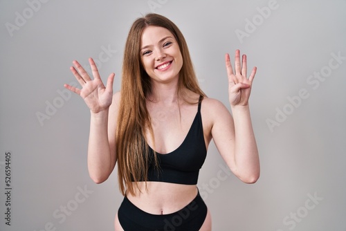 Young caucasian woman wearing lingerie showing and pointing up with fingers number nine while smiling confident and happy.