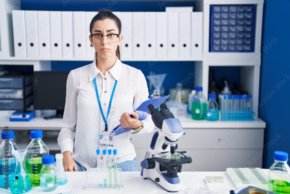 Young brunette woman working at scientist laboratory depressed and worry for distress, crying angry and afraid. sad expression. Young brunette woman working at scientist laboratory depressed and worry for distress, crying angry and afraid. sad expression.