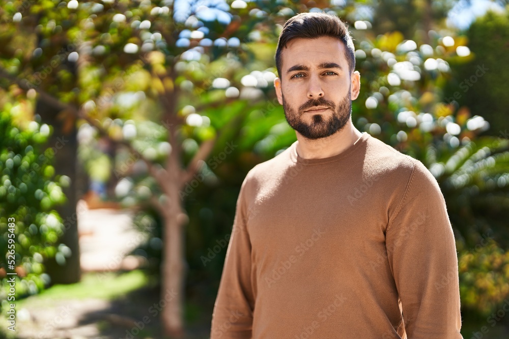 Young hispanic man with relaxed expression standing at park Young hispanic man with relaxed expression standing at park